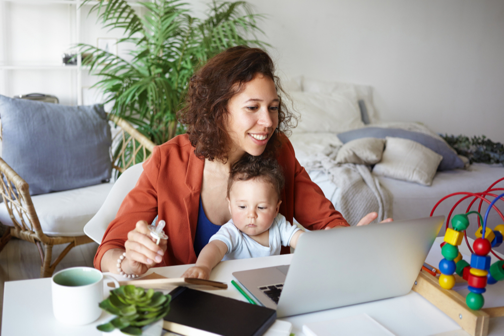 mom on computer with baby on lap